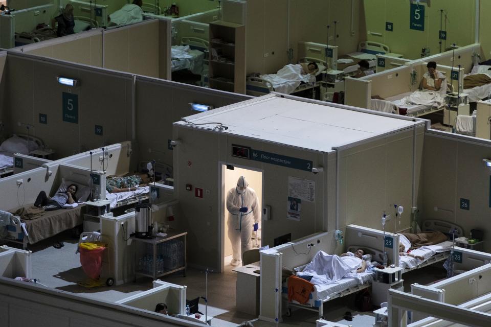 A medical worker wearing protective gear enters the treatment hall of a temporary hospital for coronavirus patients in the Krylatskoye Ice Palace in Moscow, Russia, Wednesday, Nov. 18, 2020. Russia’s health care system has been under severe strain in recent weeks, as a resurgence of the coronavirus pandemic has swept the country. (AP Photo/Pavel Golovkin)