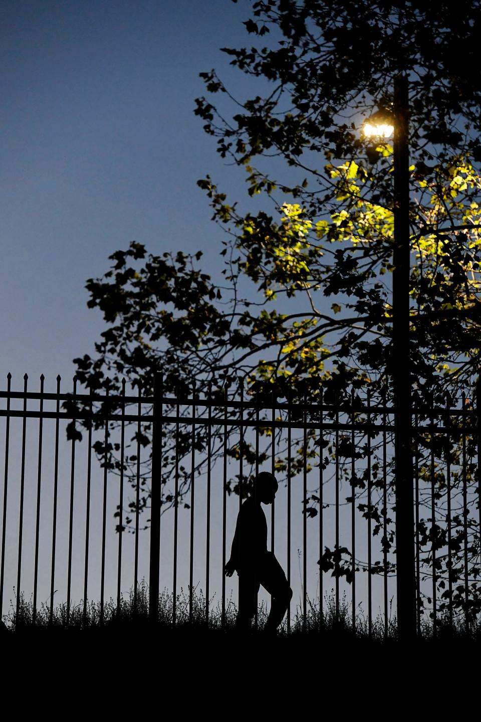 A child walks along the fence at Hillcrest Apartments in Asheville, May 31, 2020.