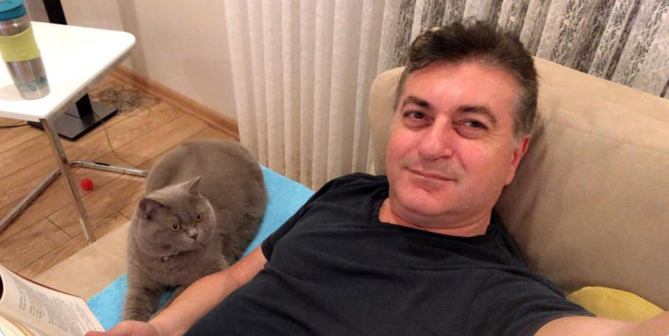 Real estate agent Mustafa Murat Ayhan, 48, is pictured with a cat.