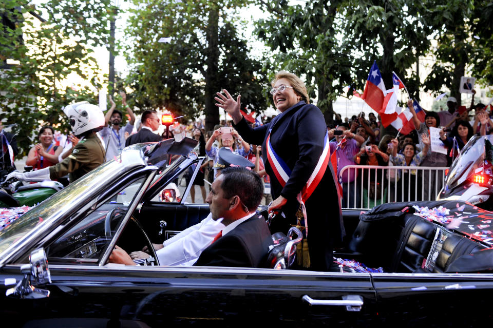 Chile's new President Michelle Bachelet waves from a car heading to La Moneda presidential palace in Santiago, Chile, Tuesday, March 11, 2014. Bachelet, who led Chile from 2006-2010, was sworn-in as president on Tuesday. (AP Photo/Victor Ruiz Caballero)