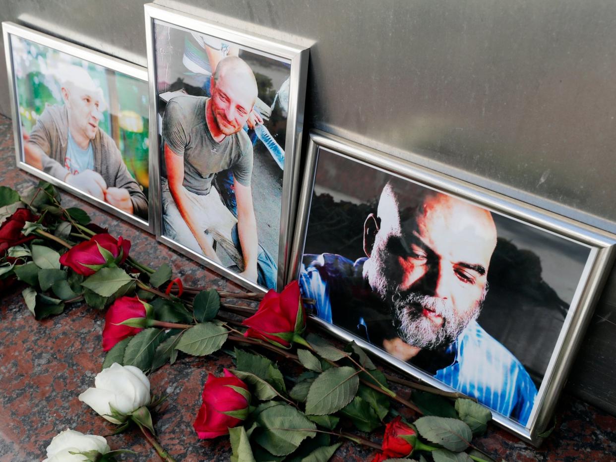 Flowers are placed as a last tribute in front of the photographs of Russian journalists Alexander Rastorguyev (L), Kirill Radchenko (C) and Orkhan Dzhemal (R) outside the Central House of Journalists in Moscow, Russia: EPA