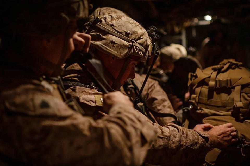 In this photo provided by U.S. Department of Defense, U.S. Marines assigned to Special Purpose Marine Air-Ground Task Force-Crisis Response-Central Command (SPMAGTF-CR-CC) 19.2, prepare to deploy from Kuwait in support of a crisis response mission, Tuesday, Dec. 31, 2019. The SPMAGTF-CR-CC is designed to move to support operations throughout the Middle East. (U.S. Marine Corps photos by Sgt. Robert G. Gavaldon via AP)