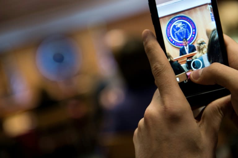 A person records proceedings during a hearing at the Federal Communications Commission meeting on "net neutrality" rules