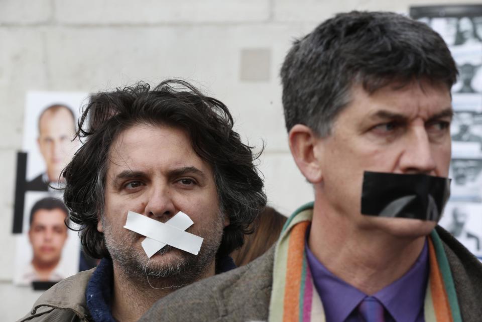 Protesters, wearing tape across their mouths, to signify the silencing of the media, participate in a rally in support of press freedom, and demanding the release of detained journalists in Egypt, in central London, Thursday, Feb. 27, 2014. The protest, part of a global day of action in support of press freedom, called for all journalists jailed in Egypt to be freed. (AP Photo/Lefteris Pitarakis)