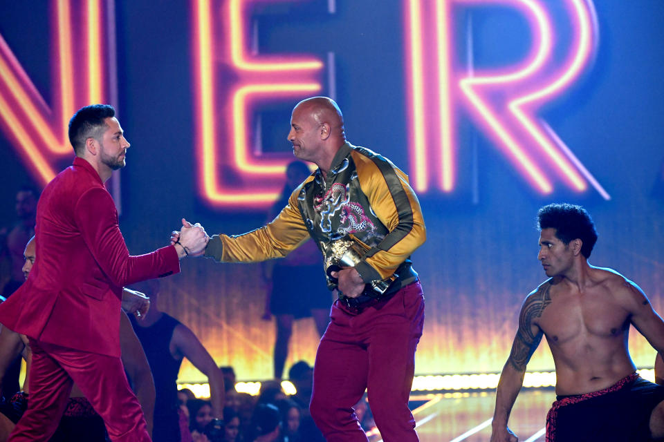SANTA MONICA, CALIFORNIA - JUNE 15: (L-R) Zachary Levi presents Dwayne Johnson with the MTV Generation Award onstage during the 2019 MTV Movie and TV Awards at Barker Hangar on June 15, 2019 in Santa Monica, California. (Photo by Kevin Winter/Getty Images for MTV)
