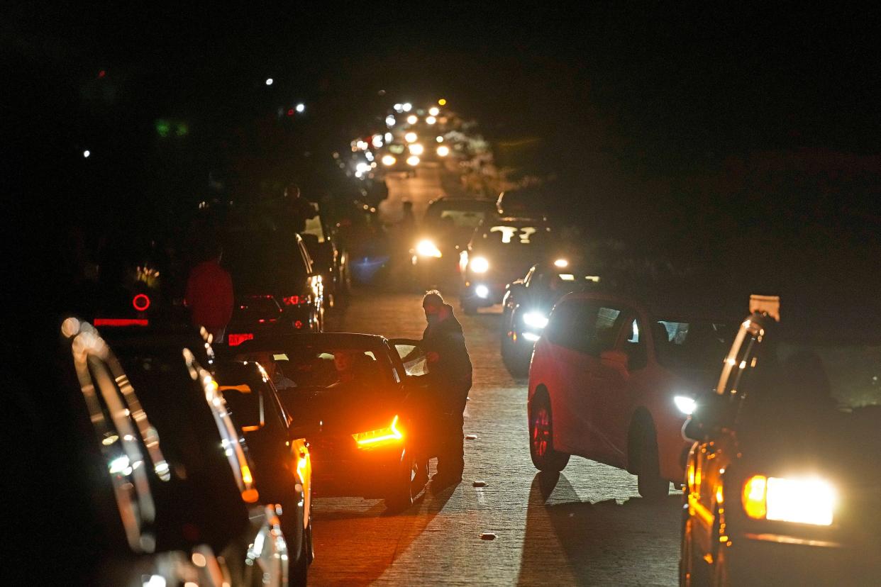 Motorists make their way along as people search for a vantage point of the erupting Mauna Loa volcano near Hilo, Hawaii, on Dec. 2.