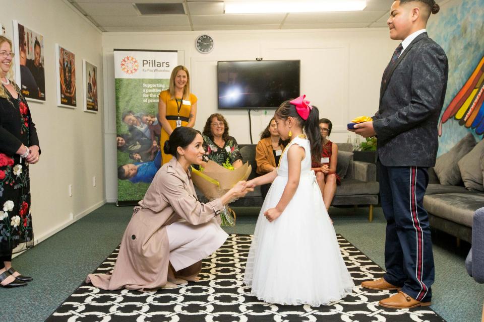 Meghan happily received flowers from Ghianna Angi during an October visit to Pillars, a New Zealand charity that supports children who have a parent in prison.