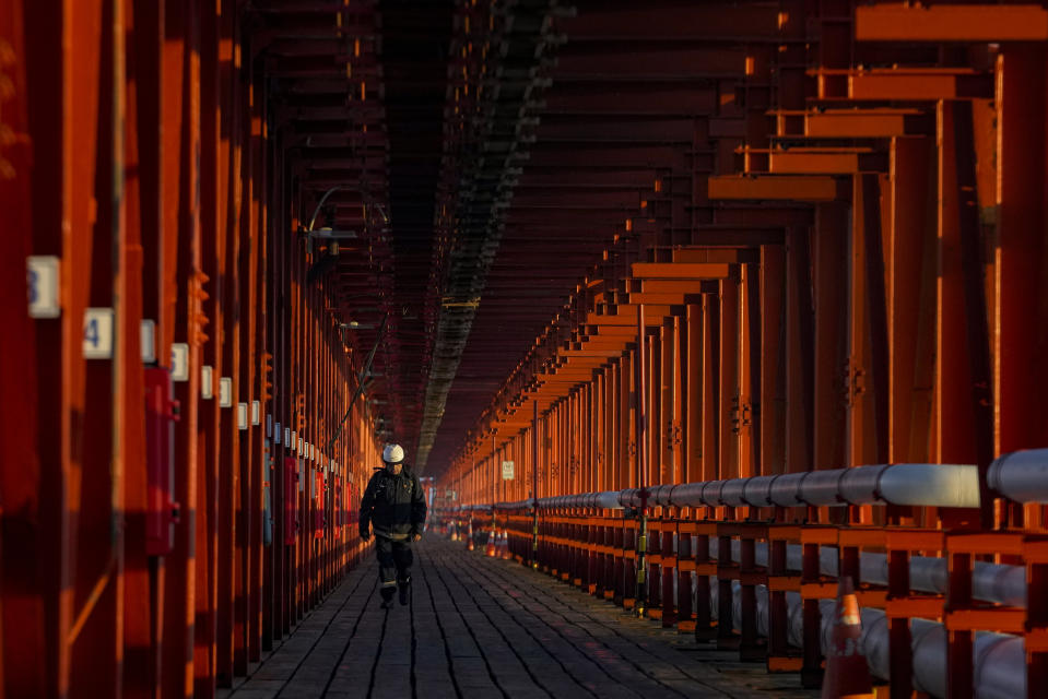 A worker walks inside the chemical company, Oxiquim, on the first day of the closure of a nearby copper factory, in Quintero Bay in Puchuncavi, Chile, Wednesday, May 31, 2023. Chilean President Gabriel Boric announced in June 2022 the gradual closure of the world's leading copper producer, Ventanas Smelter, of the state-owned company Codelco, in order to reduce the constant episodes of environmental pollution that affect the coastal communes near the furnace. (AP Photo/Esteban Felix)