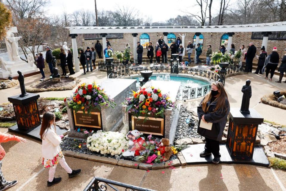 visitors lined up around grave sites located in the graceland meditation garden
