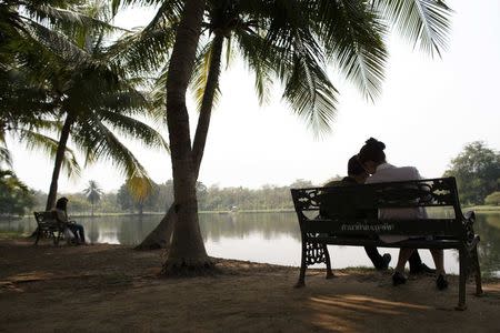 Couples sit at a park in Bangkok February 11, 2015. REUTERS/Athit Perawongmetha