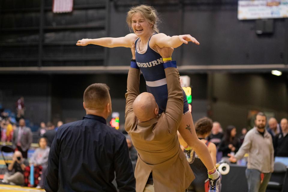 Normally a move reserved for state champions, Washburn Rural coach Damon Parker lifts Addison Broxterman into the air after she won third place in the 6-5A girls state wrestling tournament. Broxterman's pin helped clinch the team's third state title in four years.