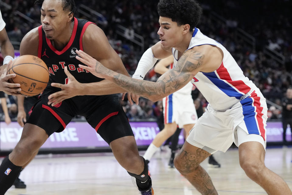 Detroit Pistons guard Killian Hayes (7) reaches in on Toronto Raptors forward Scottie Barnes (4) during the first half of an NBA basketball game, Saturday, Dec. 30, 2023 in Detroit. (AP Photo/Carlos Osorio)