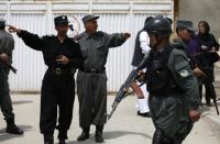 Afghan policemen stand outside Cure Hospital after three Americans were killed in Kabul April 24, 2014. (REUTERS/Mohammad Ismail)