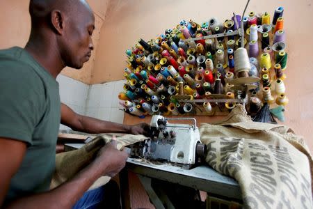 A man works on a sewing machine inside the workshop of Ivory coast fashion designer Liliane Estievenart, 45, in Abidjan, Ivory Coast July 22, 2017. REUTERS/Thierry Gouegnon