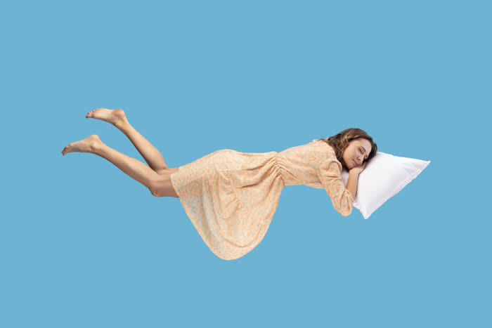 mujer con una almohada volando