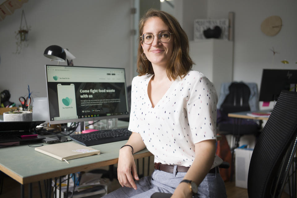 In this Tuesday, May 21, 2019 photo, Franziska Lienert spokeswoman of the company which runs the food sharing app 'Too Good To Go', poses for a photo at her working desk during an interview with the Associated Press in Berlin. In Germany, growing numbers of people use modern technology such as phone apps to help reduce food waste. In an effort to cut down on climate-wrecking carbon dioxide emissions created by food waste, they build online communities to share food before throwing it away. (AP Photo/Markus Schreiber)