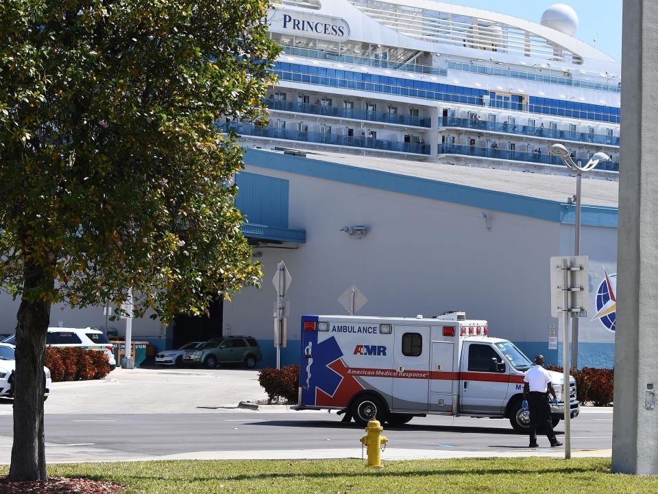 An ambulance takes a patient from the cruise ship Coral Princess to the hospital as the ship is docked at the Port of Miami, Florida