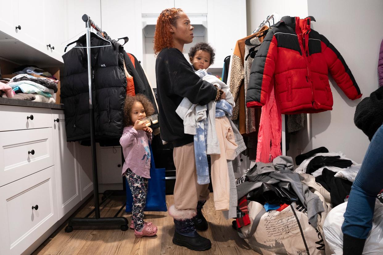 Jan 25, 2024; Columbus, OH, United States; Natalia Sonney holds her son Zymeir Sonney, 8 months, as her daughter Zyra Dorsey stays busy while they look through available clothing during a transition-aged youth palooza event. being held at the Kenmore Community Center. Sonney is currently living at Kenmore Square, an apartment complex owned by Huckleberry House which provides housing to people age 17 to 24.