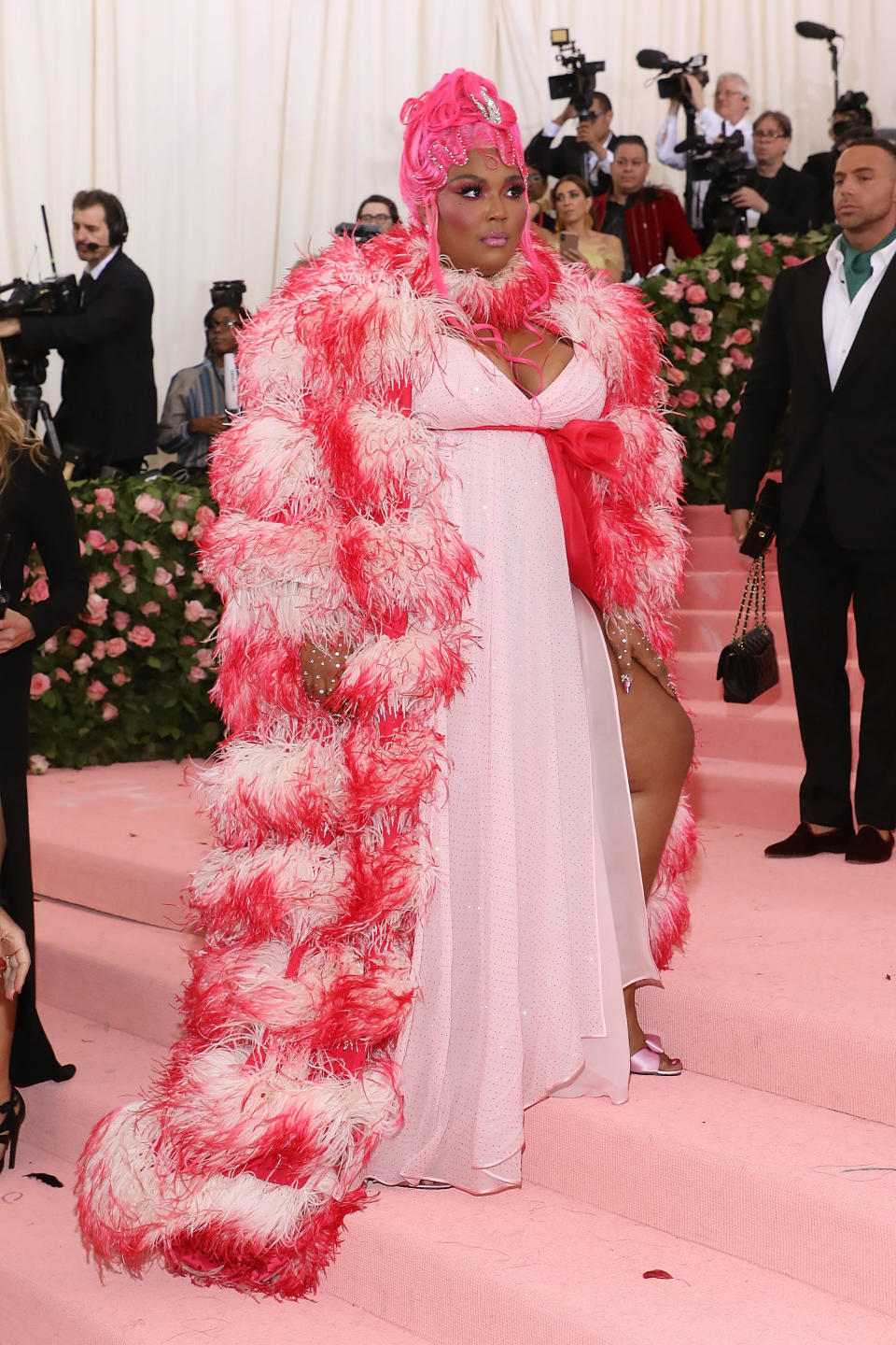 Celebrity in extravagant feathered outfit with headpiece at a gala event