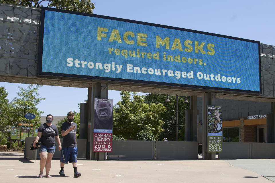 Visitors leave the Henry Doorly Zoo in Omaha, Neb., Monday, July 27, 2020, where face mask wearing is required indoors and encouraged in the outdoor areas. Nebraska's online virus tracker on Monday showed 800 cases were confirmed Friday through Sunday, bringing the state's total to 24,618 since the outbreak began. That included 356 cases confirmed on Friday, 221 on Saturday and 223 on Sunday. (AP Photo/Nati Harnik)