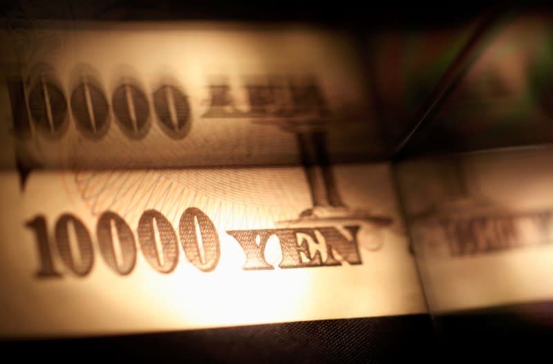 Light is cast on a Japanese 10,000 yen note as it's reflected in a plastic board in Tokyo, in this February 28, 2013 picture illustration. REUTERS/Shohei Miyano/Illustration/File Photo