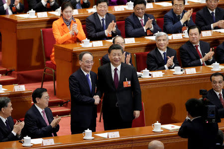 Chinese President Xi Jinping (center R) shakes hands with newly elected Chinese Vice President Wang Qishan at the fifth plenary session of the National People's Congress (NPC) at the Great Hall of the People in Beijing, China March 17, 2018. REUTERS/Jason Lee