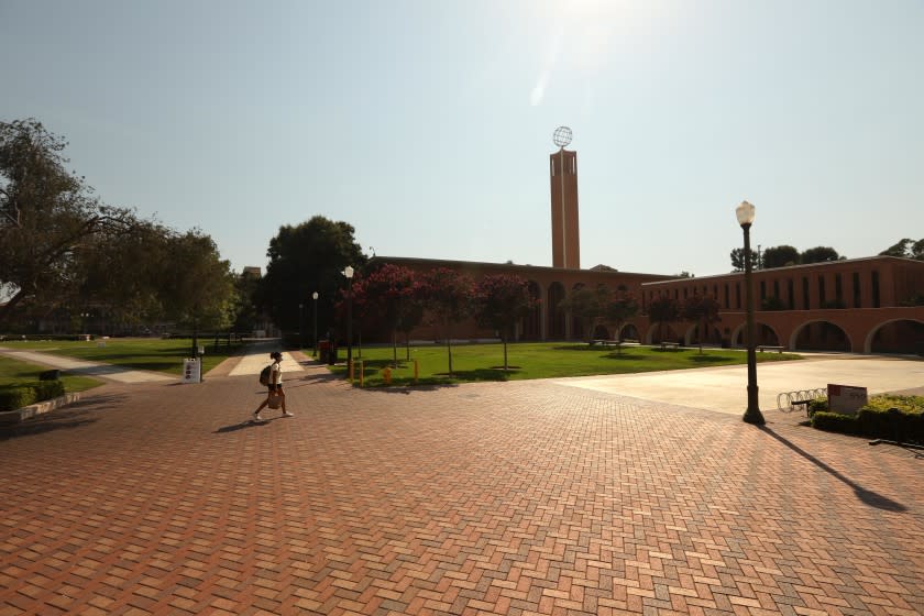 LOS ANGELES, CA - AUGUST 17, 2020 - - A lone student walks across an empty section of the USC campus on the first day of academic instruction for the Fall 2020 semester in Los Angeles on August 17, 2020. Students were taking online courses due to the coronavirus pandemic and the campus was nearly empty. (Genaro Molina / Los Angeles Times)