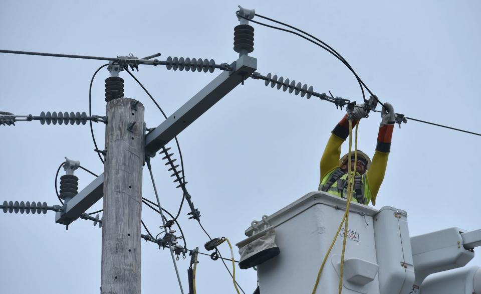 An electric lineman from One Source Power in Boston works to restring a power line along Route 6A in Orleans which fell atop the Route 6 overpass onto the road, closing it until it could be removed.