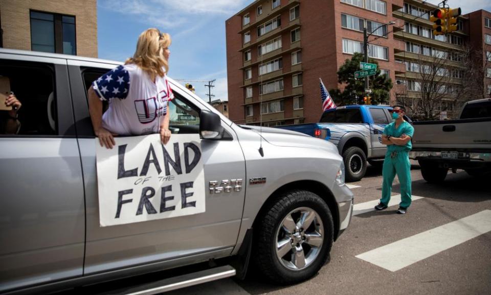 Health care workers stand in the street as a counter-protest to those demanding the stay-at-home order be lifted in Denver on April 19th.