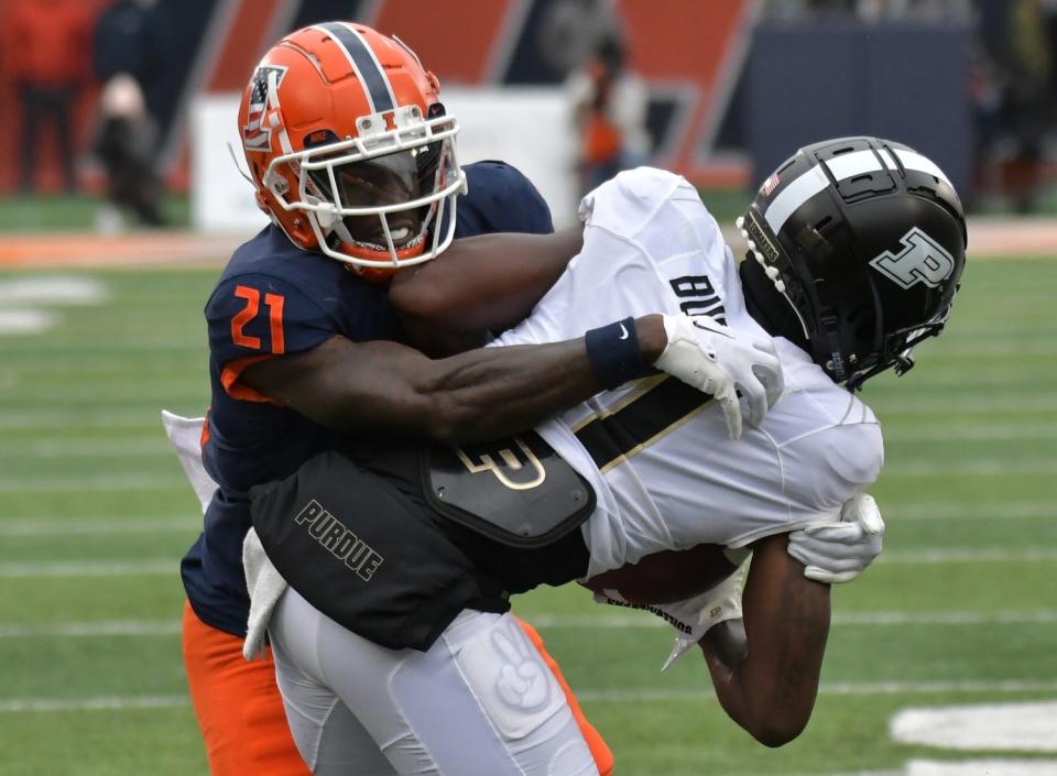 Illinois Fighting Illini defensive back Jartavius Martin (21) tackles Purdue Boilermakers wide receiver Deion Burks (4) during the first half at Memorial Stadium on Nov. 12, 2022.