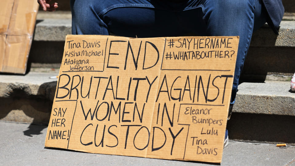 A person holds a sign at the #whatabouther rally for women being held at Riker's Island in front of the New York Stock exchange on April 26, 2021 in New York City. (Michael M. Santiago/Getty Images)