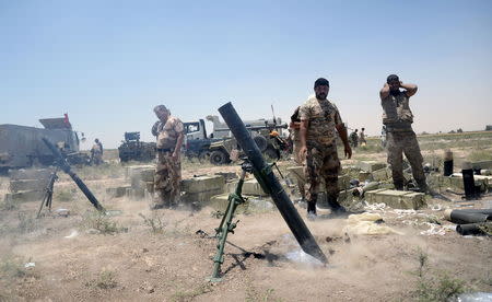 Iraq's Shi'ite paramilitaries launch a mortar toward Islamic State militants at North of Fallujah in province of Anbar, July 6, 2015. REUTERS/Stringer