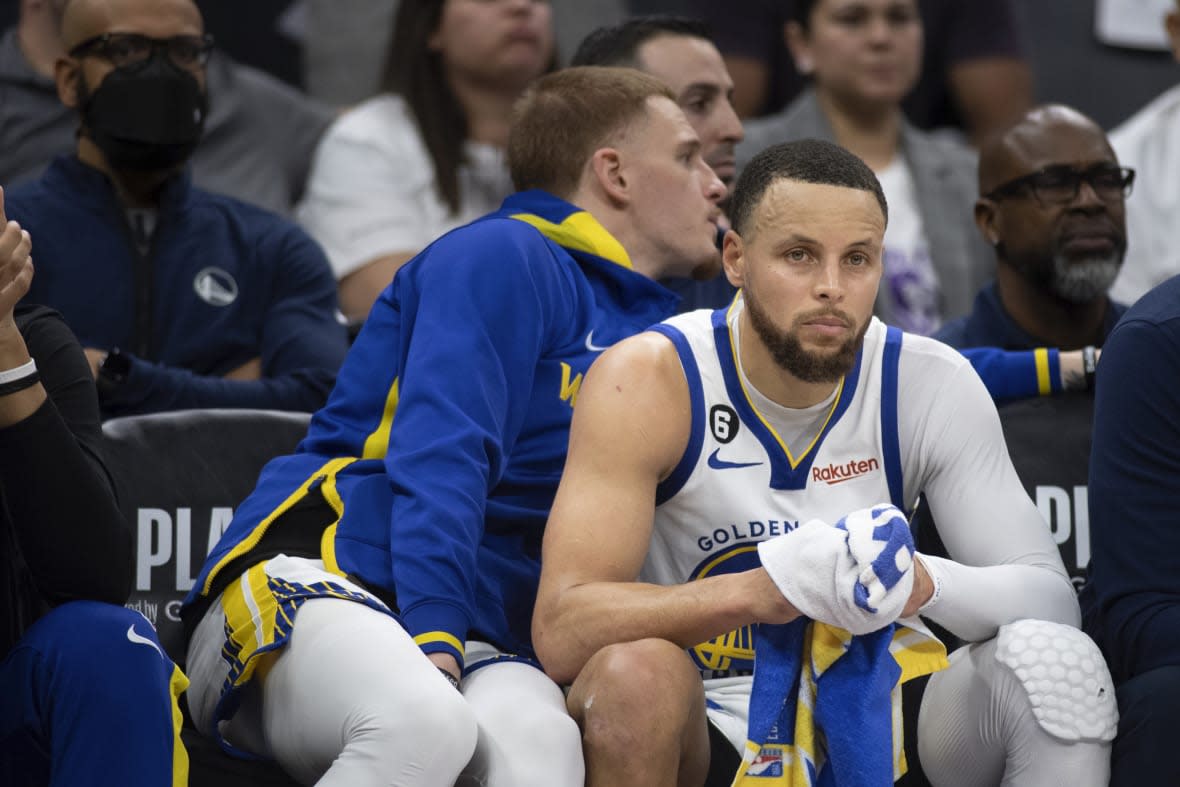 Golden State Warriors guard Stephen Curry (30) watches from the bench in the third quarter during Game 1 against the Sacramento Kings in the first round of the NBA basketball playoffs in Sacramento, Calif., Saturday, April 15, 2023. The Kings won 126 – 123. (AP Photo/José Luis Villegas)