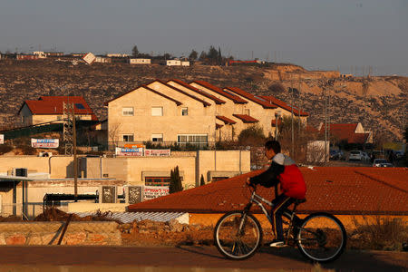 A boy rides his bicycle past houses in the Israeli settlements of Ofra, in the occupied West Bank February 6, 2017. REUTERS/Baz Ratner