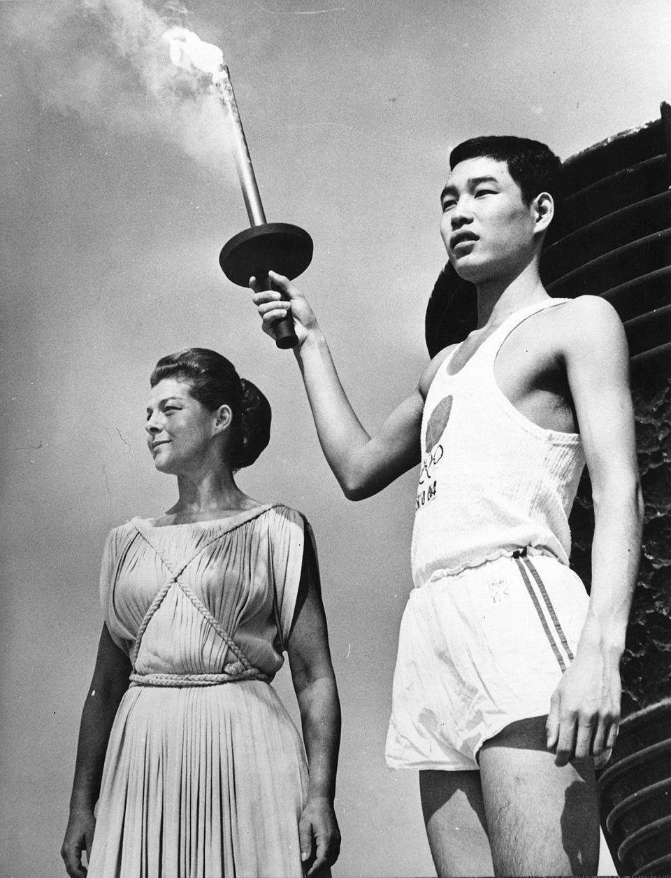 <p>Sakai, who was born in Hiroshima on the day the first atomic bomb was dropped on the city, holds the Olympic torch next to Greek actress Aleka Katselli during a rehearsal for the opening of the Olympic Games.</p>