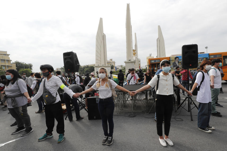 Anti-government protesters hold the hands together for security during a protest near Democracy Monument in Bangkok, Thailand, Wednesday, Oct. 14, 2020. Thai political activists hope to keep up the momentum for their campaign for democratic change with their third major rally in the capital Bangkok on Wednesday. (AP Photo/Sakchai Lalit)