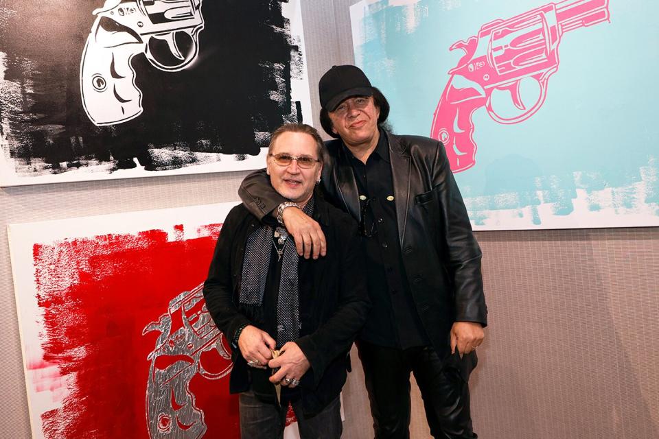 Kiss drummer Eric Singer (L) and Kiss singer/bassist Gene Simmons pose in front of some of Simmons' works at the debut of Gene Simmons ArtWorks at Animazing Gallery at The Venetian Las Vegas on October 21, 2021 in Las Vegas, Nevada.
