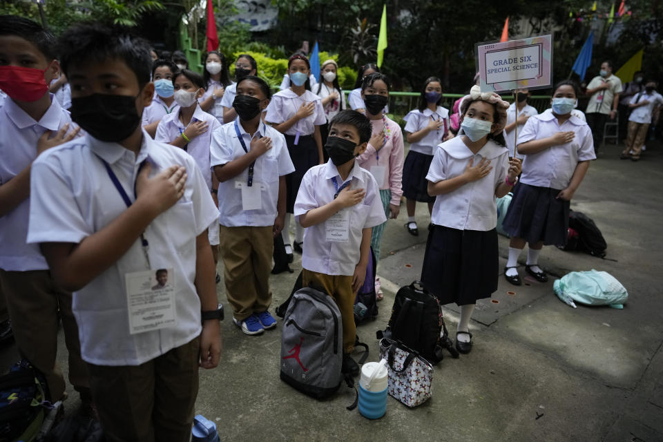 Students attend a flag raising ceremony during the opening of classes at the San Juan Elementary School in metro Manila, Philippines on Monday, Aug. 22, 2022. Millions of students wearing face masks streamed back to grade and high schools across the Philippines Monday in their first in-person classes after two years of coronavirus lockdowns that are feared to have worsened one of the world's most alarming illiteracy rates among children. (AP Photo/Aaron Favila)