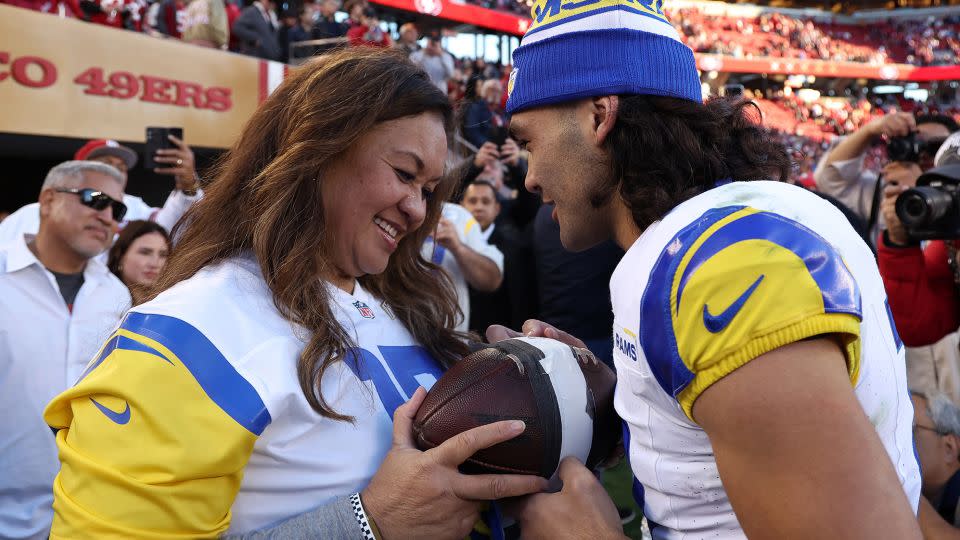 Nacua hands the record-breaking ball to his mother, Penina Nacua, after breaking the rookie receiving yards record against the 49ers. - Ezra Shaw/Getty Images