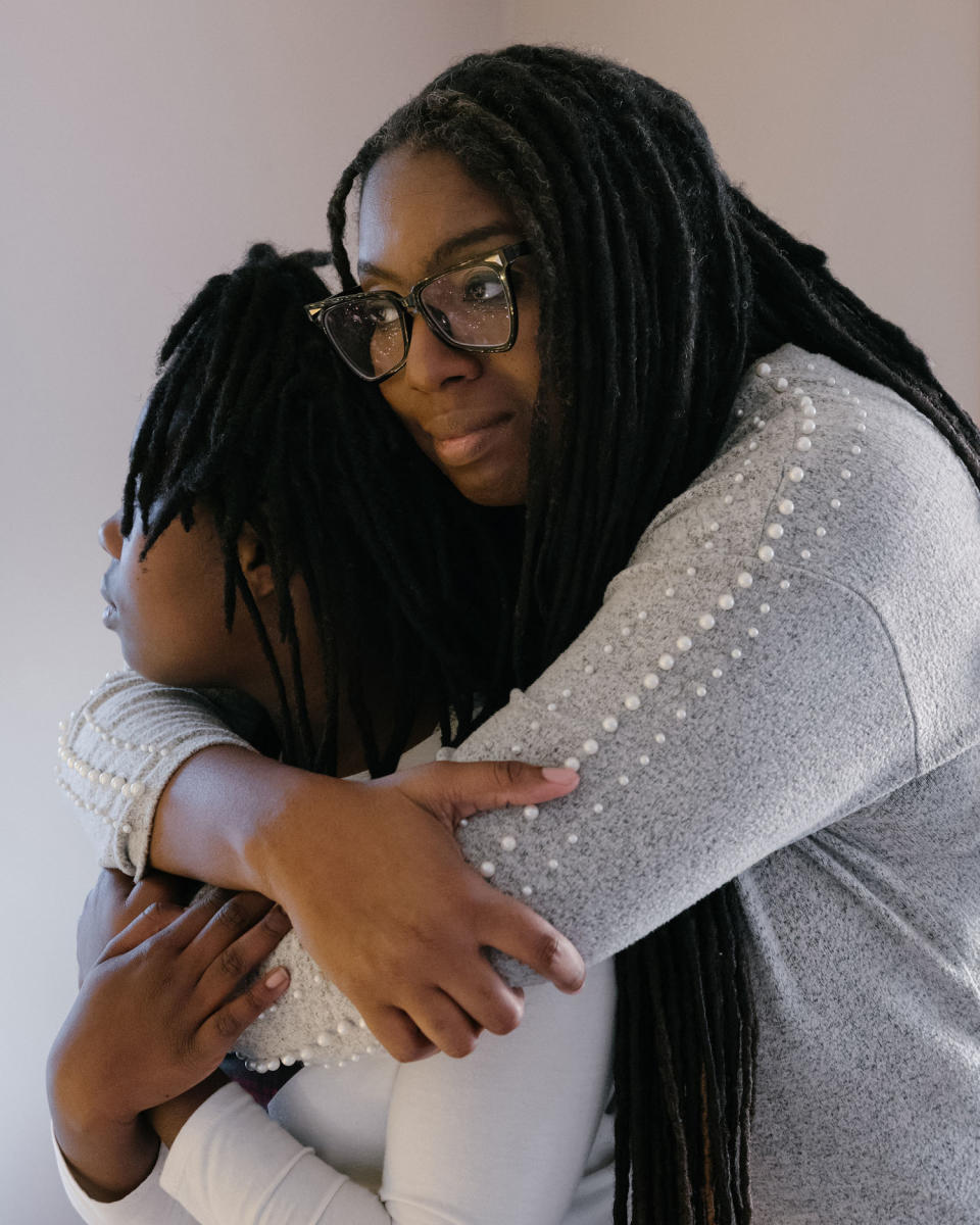 Benton holds her daughter in their home on Dec. 16. (Caroline Gutman for NBC News)