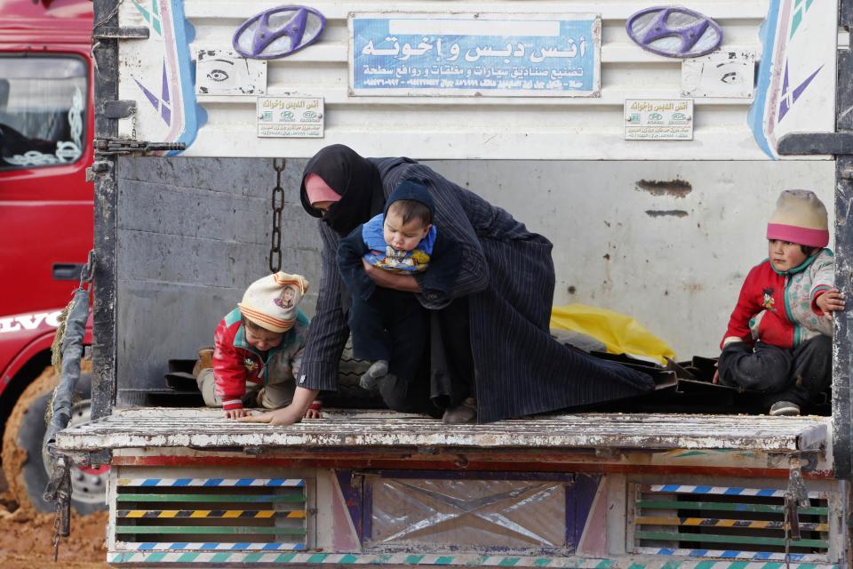 Syrian refugees, who fled the violence in their country, climb off a pick-up truck at the Lebanese border town of Arsal, in the eastern Bekaa Valley December 10, 2013. The Social Affairs Ministry announced Tuesday that it started to execute a plan for helping the displaced Syrians in Lebanon amidst the snow storm expected to strike Lebanon today evening, the National News Agency (NNA) reported. REUTERS/Mohamed Azakir (LEBANON - Tags: POLITICS CIVIL UNREST SOCIETY IMMIGRATION CONFLICT)