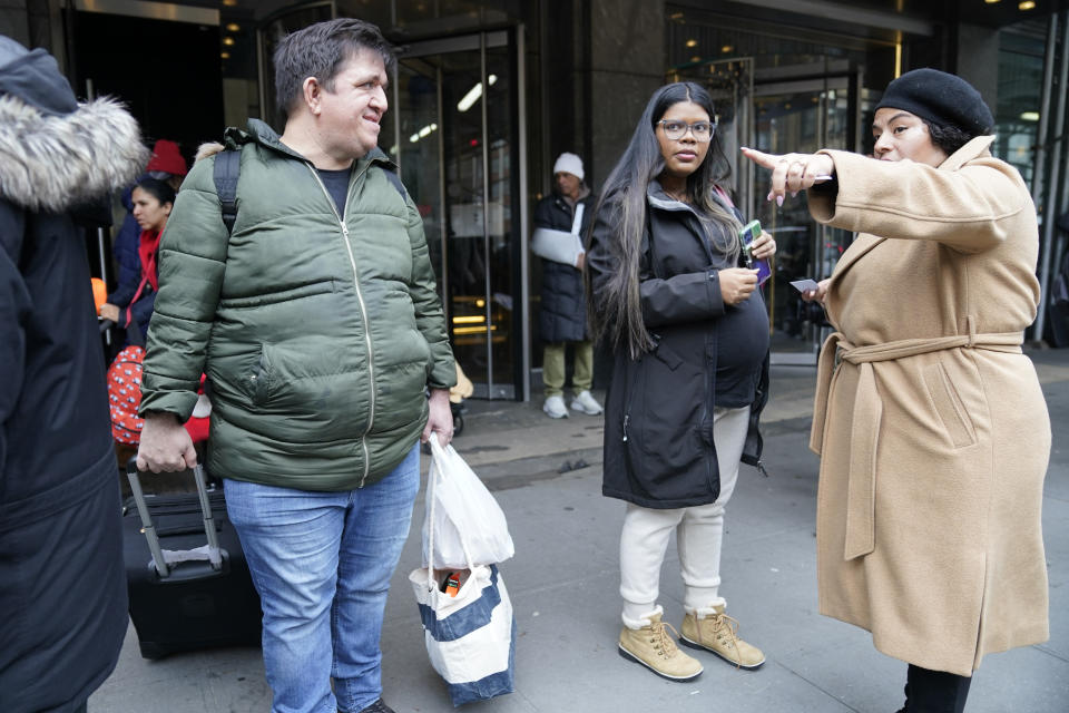 FILE - David Quero, left, and his a pregnant Maria Quero, center, from Venezuela, leave the Row Hotel with their belongings, Tuesday, Jan. 9, 2024, in New York. A New York City policy imposing 60-day limits on shelter stays for migrant families has been rolled out haphazardly over the past six months — with the city failing to notify pregnant women that they may be exempt, a new audit by the city's comptroller has found. (AP Photo/Mary Altaffer, File)