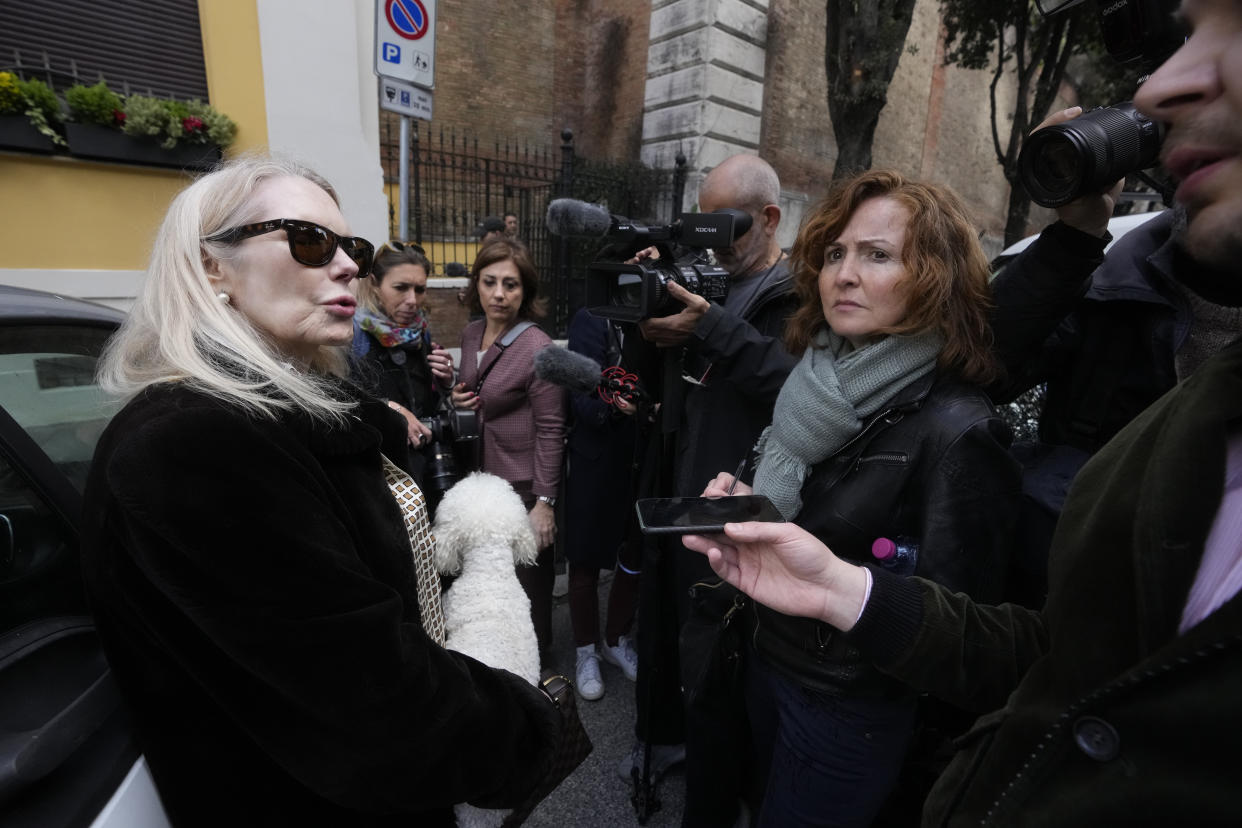Texas-born Princess Rita Boncompagni Ludovisi, born Rita Jenrette Carpenter, left, and last wife of late Prince Nicolo Boncompagni Ludovisi, talks to journalists a she leaves her residence, The Casino dell'Aurora, also known as Villa Ludovisi, during the execution of an eviction order, in Rome, Thursday, April 20, 2023. The villa contains the only known ceiling painted by Caravaggio and Princess Ludovisi is facing a court-ordered eviction Thursday, in the latest chapter in an inheritance dispute with the heirs of one of Rome's aristocratic families. (AP Photo/Andrew Medichini)