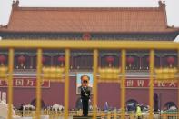 A paramilitary policeman stands guard before a giant portrait of late Chinese Chairman Mao Zedong at the Tiananmen gate, a day before the 19th National Congress of the Communist Party of China begins, in Beijing. REUTERS/Aly Song