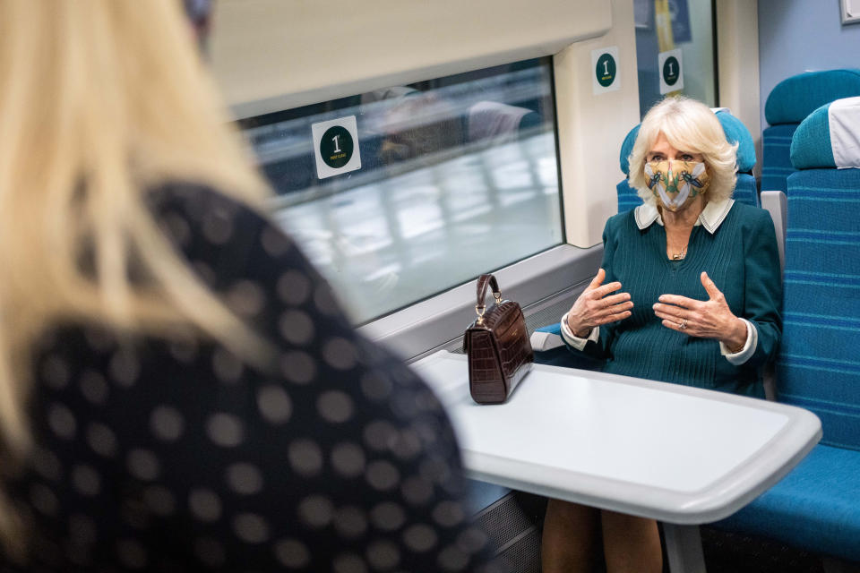 Handout photo issued by the Rail Delivery Group of the Duchess of Cornwall speaking with a representative from Rail to Refuge in a train carriage during a visit to Victoria Station in London, Rail to Refuge is a collaboration between train operators and Women's Aid which enables survivors fleeing domestic abuse to access free train travel to a safe refuge. Issue date: Tuesday March 30, 2021.