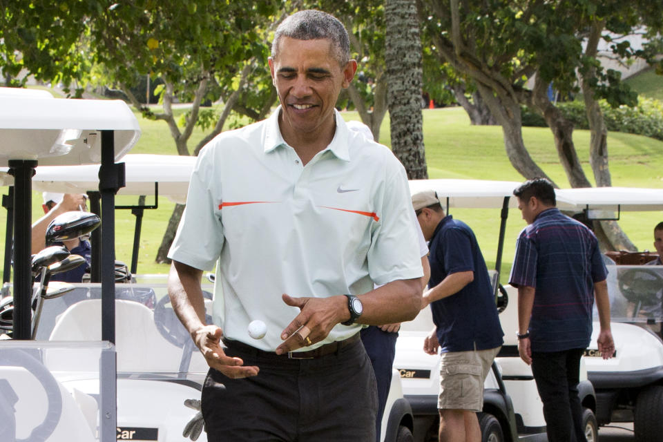 FILE - President Barack Obama tosses a golf ball between his hands after finishing the 18th hole of golf with Malaysian Prime Minister Najib Razak Wednesday, Dec. 24, 2014, at Marine Corps Base Hawaii's Kaneohe Klipper Golf Course in Kaneohe, Hawaii during the Obama family vacation. The Associated Press reported on stories circulating online incorrectly claiming recent bandages around former President Barack Obama’s hand are suspicious and suggest he was involved in the death of his personal chef last month. (AP Photo/Jacquelyn Martin, File)