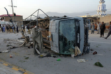 Policemen and locals gather near a destroyed police truck, after three suicide bomb attacks in southwestern city of Quetta, Pakistan April 24, 2018. REUTERS/Naseer Ahmed