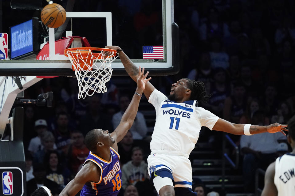 Minnesota Timberwolves center Naz Reid (11) misses a dunks as Phoenix Suns center Bismack Biyombo (18) defends during the second half of an NBA basketball game Wednesday, March 29, 2023, in Phoenix. The Suns won 107-100. (AP Photo/Ross D. Franklin)