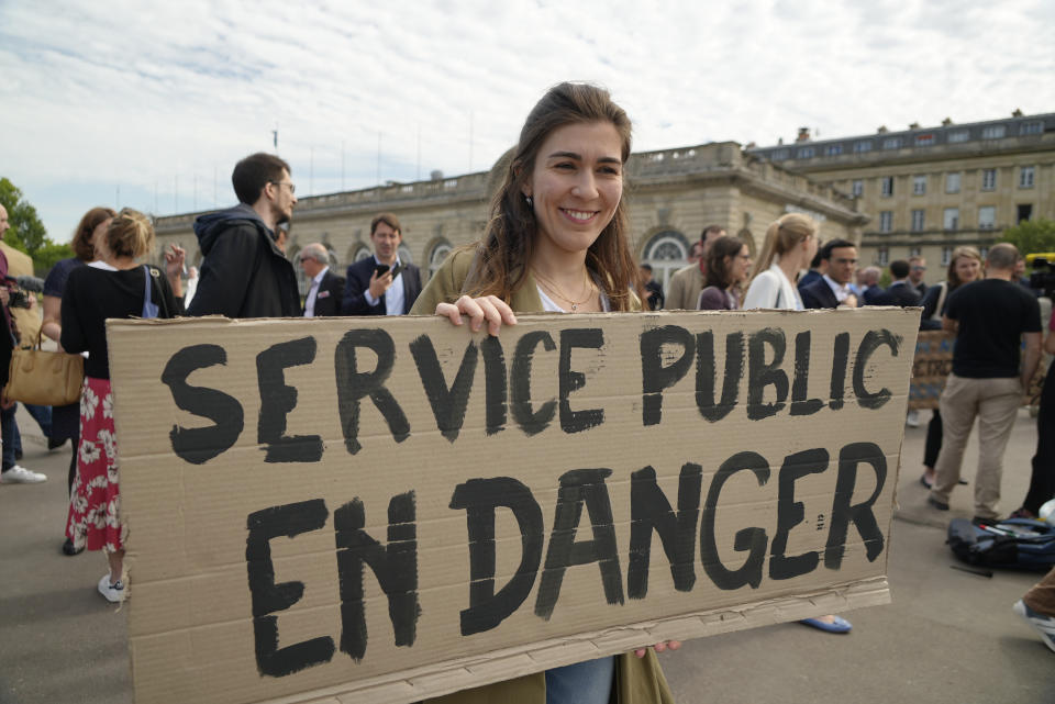 A woman holds a poster reading "Public service in danger" as diplomats strike near the French Foreign Ministry Thursday, June 2, 2022 in Paris. Members of the French diplomatic corps are dropping their traditional reserve to go on a rare strike, angered by a planned reform they worry will hurt their careers and France's standing in the world. (AP Photo/Nicolas Garriga)