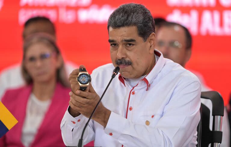 El presidente Nicolás Maduro muestra un reloj que le regaló Diego Maradona durante una cumbre en Caracas. (JUAN BARRETO / AFP)